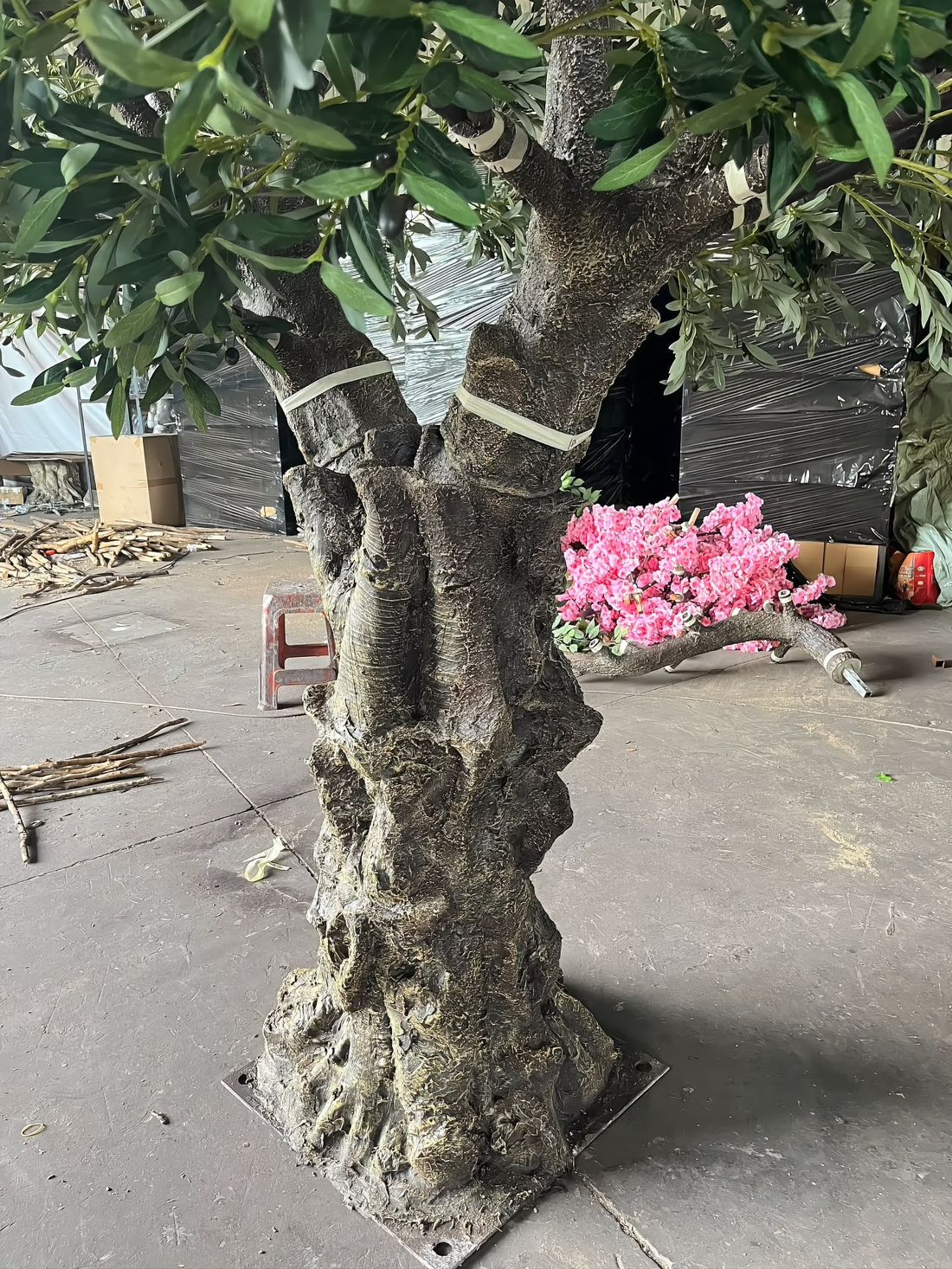 树干基部细节：玻璃钢根盘裹在螺栓固定的钢底板上